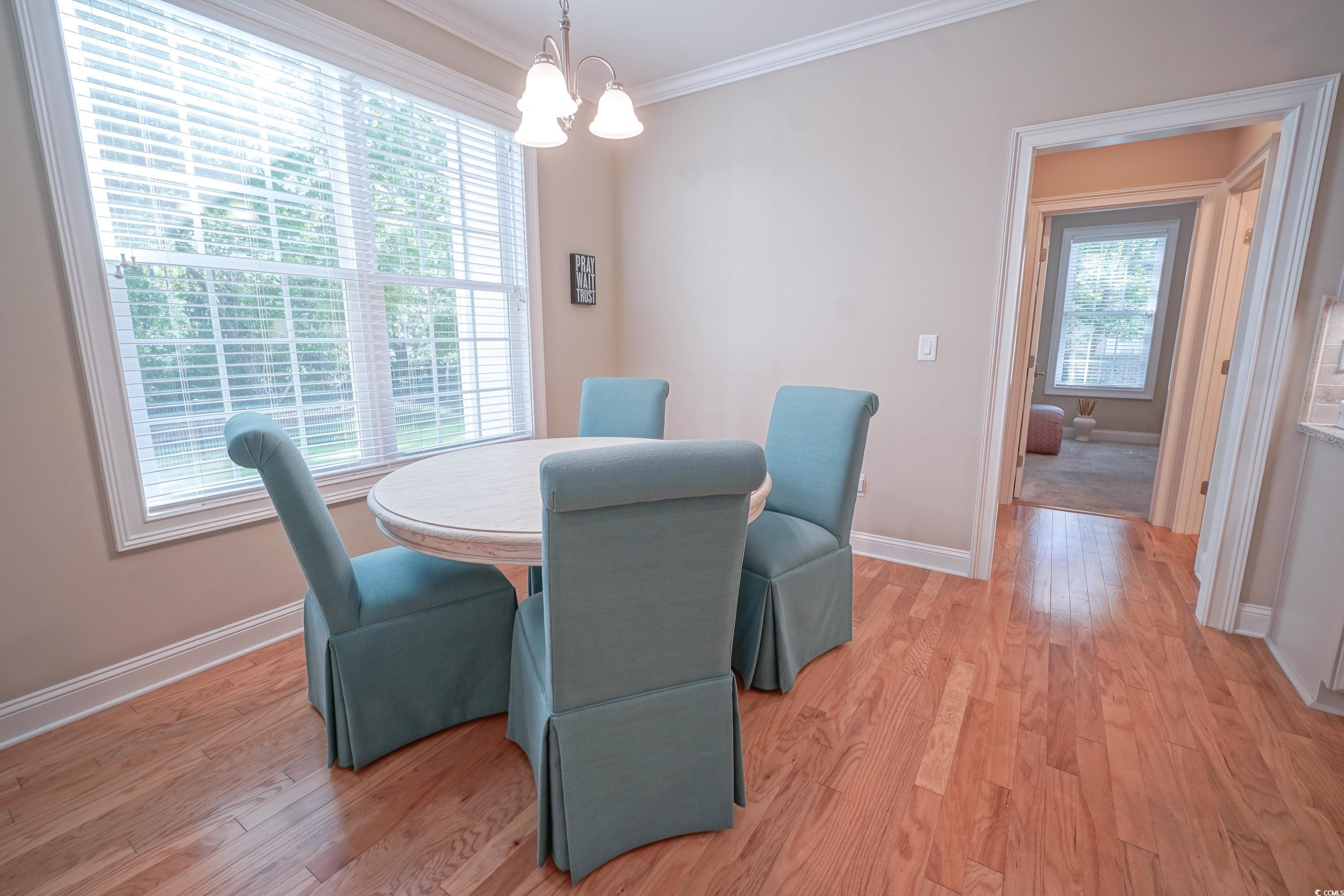 625 Whispering Pines Court Murrells Inlet, SC 29576 - Photo 11 of 36 Dining room featuring an inviting chandelier, baseboards, ornamental molding, and light wood-style flooring