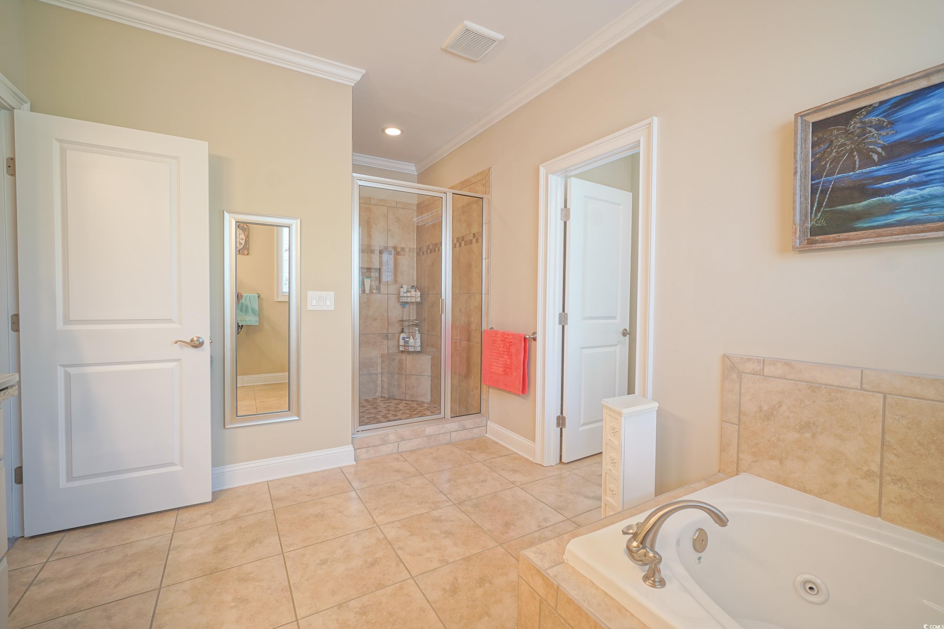 625 Whispering Pines Court Murrells Inlet, SC 29576 - Photo 17 of 36 Bathroom with a stall shower, baseboards, crown molding, and a whirlpool tub