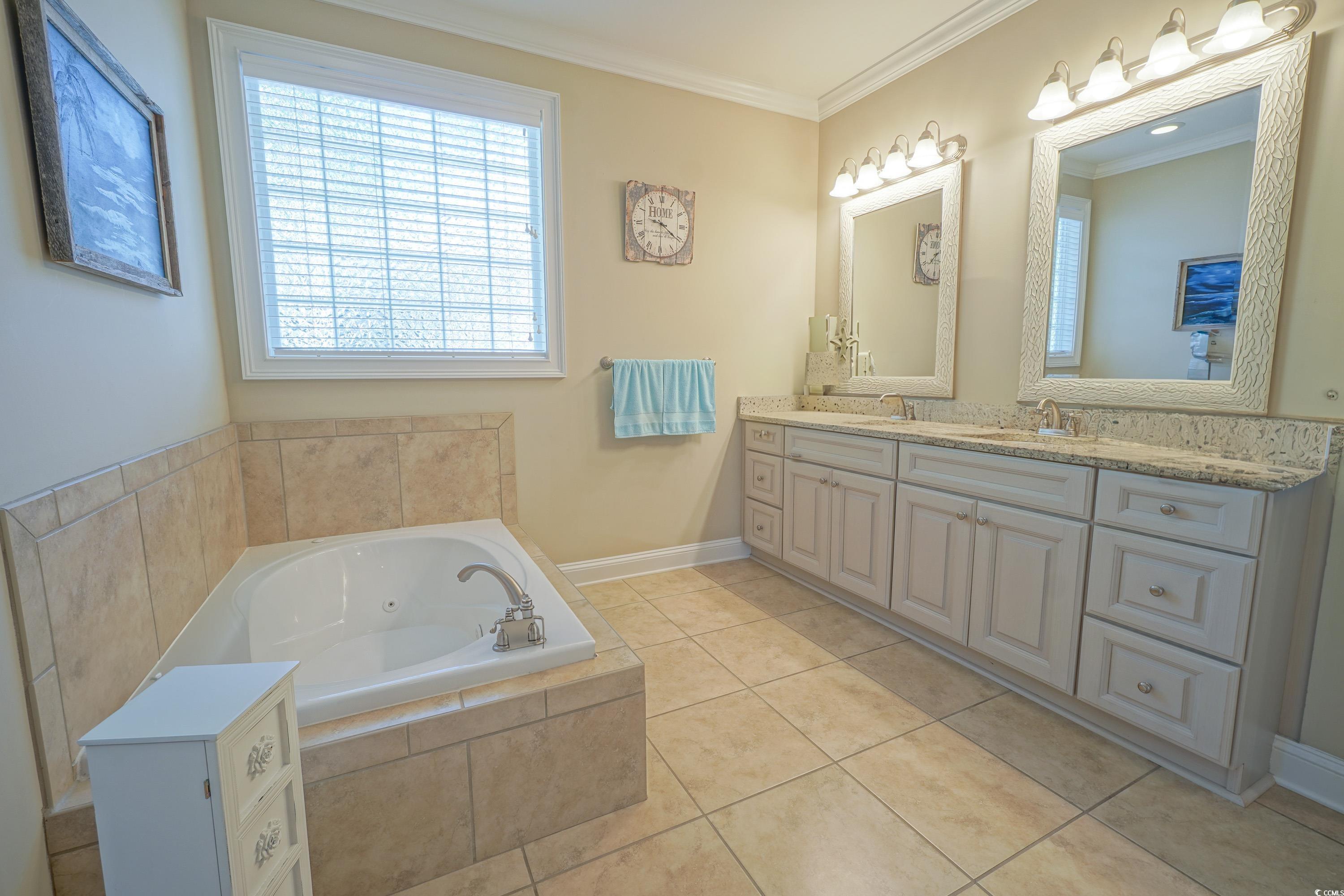 625 Whispering Pines Court Murrells Inlet, SC 29576 - Photo 18 of 36 Bathroom featuring a sink, crown molding, double vanity, and a bath