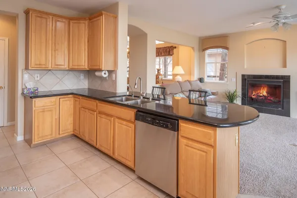 a kitchen with stainless steel appliances a sink cabinets and a fireplace