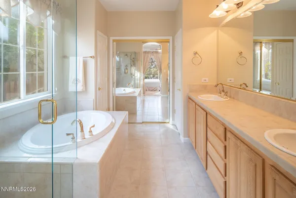 a spacious bathroom with a tub sink and mirror