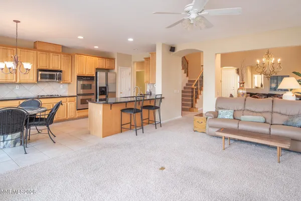 a living room with furniture kitchen view and a large window