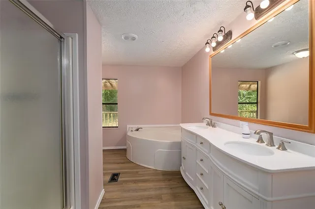 a spacious bathroom with a granite countertop sink mirror and a bathtub