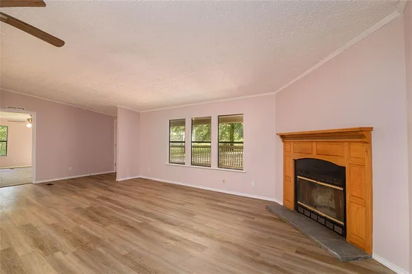 a view of an empty room with a fireplace and a window