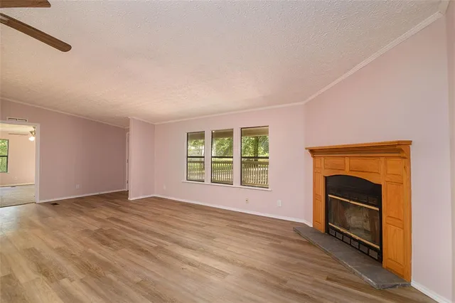 a view of an empty room with a fireplace and a window
