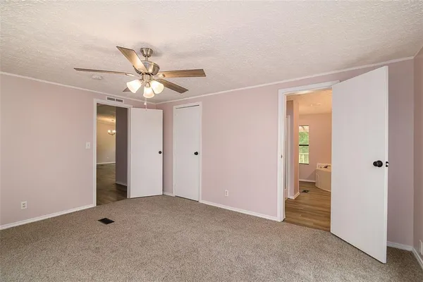 a view of an empty room with window and a ceiling fan