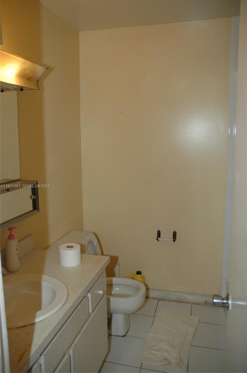 5300 Washington Street, Unit Q307 Hollywood, FL 33021 - Photo 12 of 21 a bathroom with a granite countertop toilet and a sink