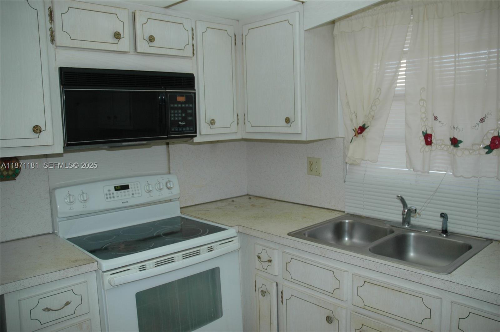 5300 Washington Street, Unit Q307 Hollywood, FL 33021 - Photo 7 of 21 a kitchen with cabinets appliances and a sink