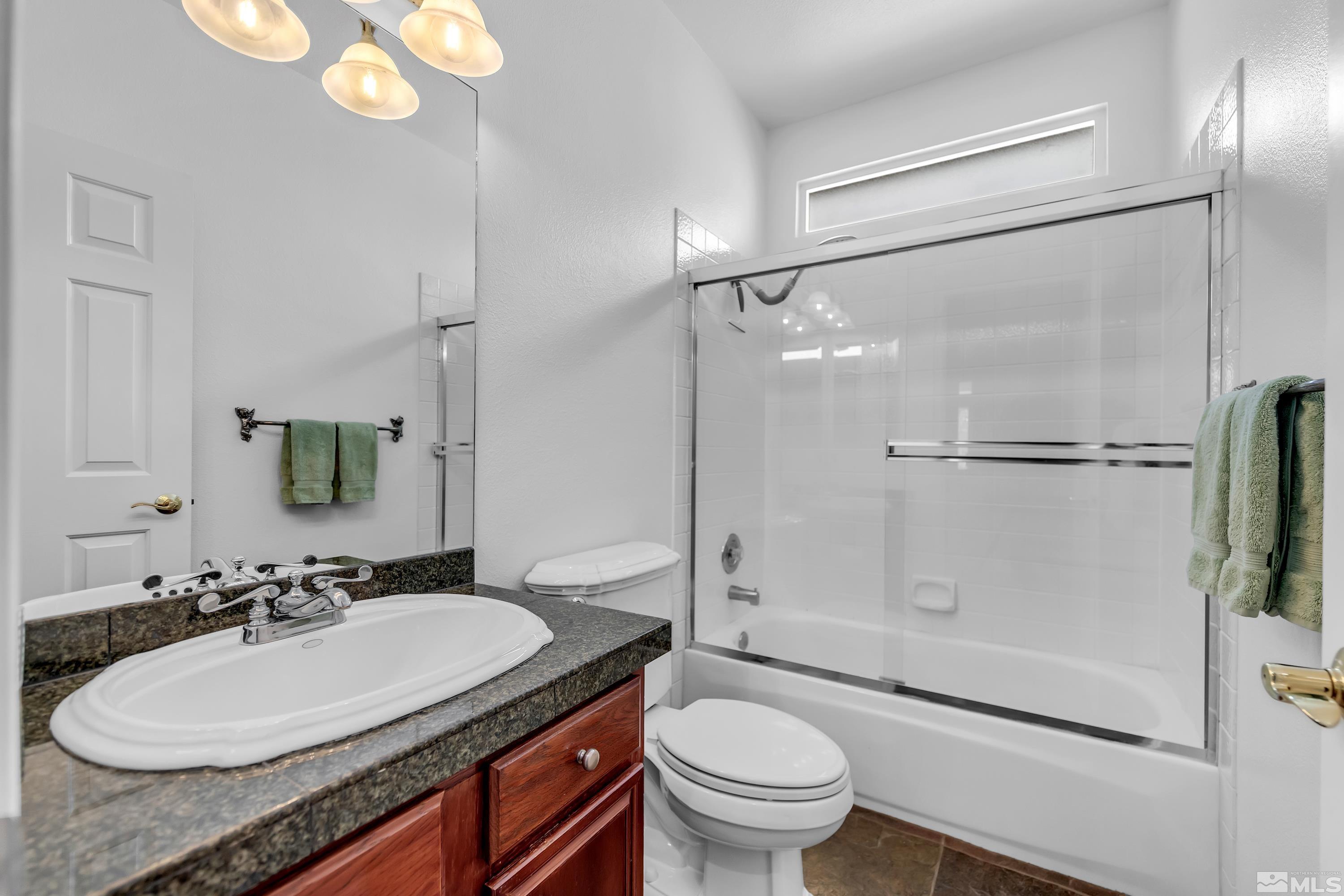 809 Caughlin Glen Reno, NV 89519 - Photo 14 of 23 a bathroom with a granite countertop sink toilet mirror and a shower