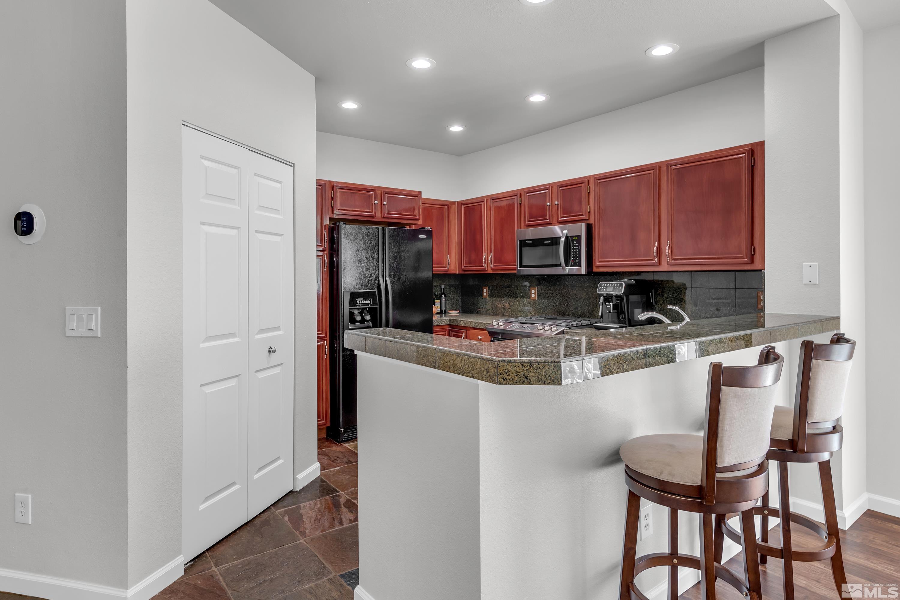 809 Caughlin Glen Reno, NV 89519 - Photo 6 of 23 a kitchen with kitchen island granite countertop wooden cabinets and stainless steel appliances