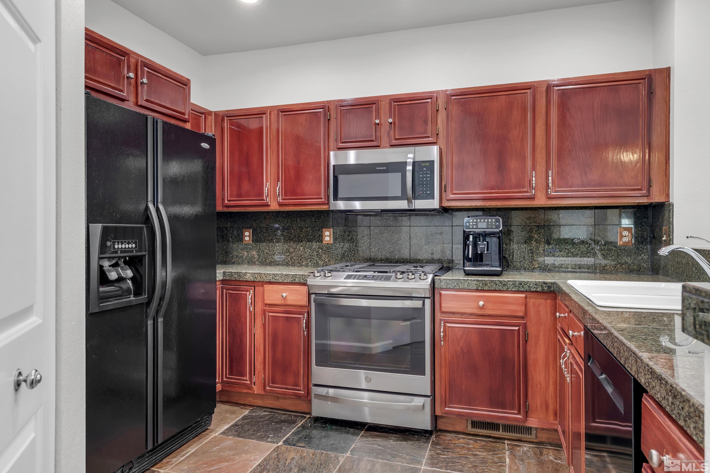 809 Caughlin Glen Reno, NV 89519 - Photo 7 of 23 a kitchen with stainless steel appliances granite countertop a stove top oven a refrigerator and dishwasher with wooden cabinets