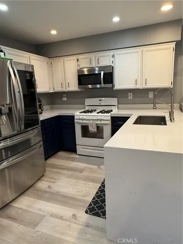 a kitchen with kitchen island granite countertop a sink stainless steel appliances and cabinets
