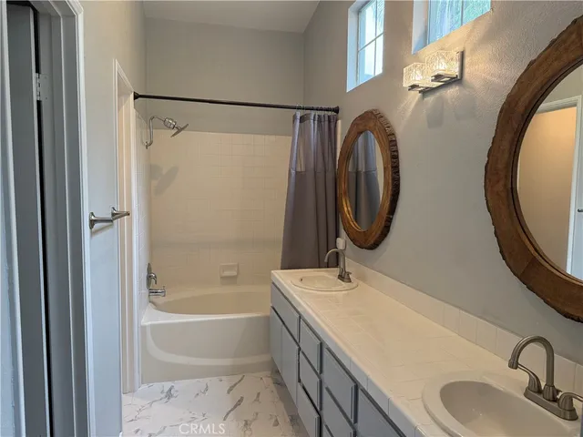 a bathroom with a granite countertop sink mirror bathtub and shower