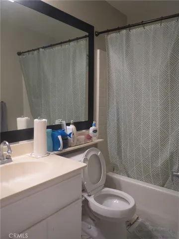 a bathroom with a sink a toilet and shower curtain