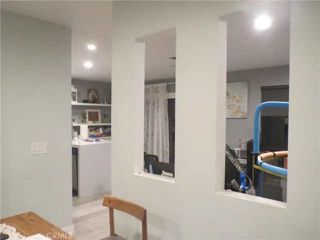 a view of hallway with chair and frames on wall