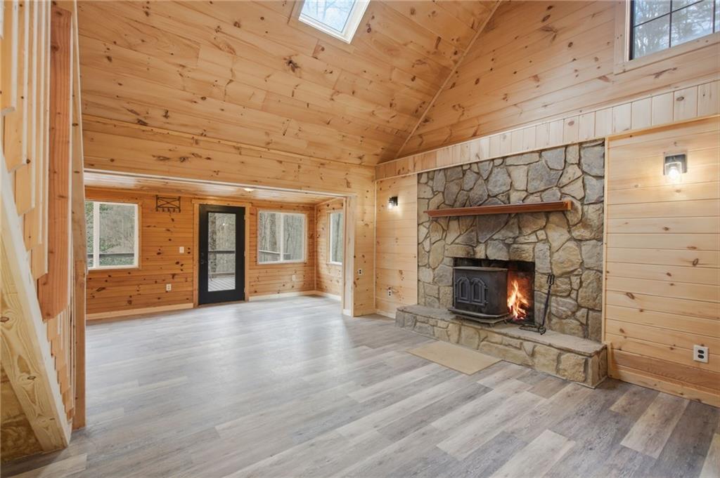 1780 Conasauga Road Ellijay, GA 30540 - Photo 4 of 43 an empty room with wooden floor fireplace and windows