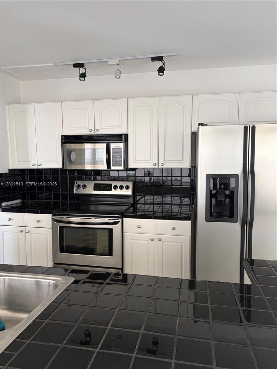 3205 Liberty Street Hollywood, FL 33021 - Photo 5 of 12 a kitchen with granite countertop a refrigerator and a stove top oven