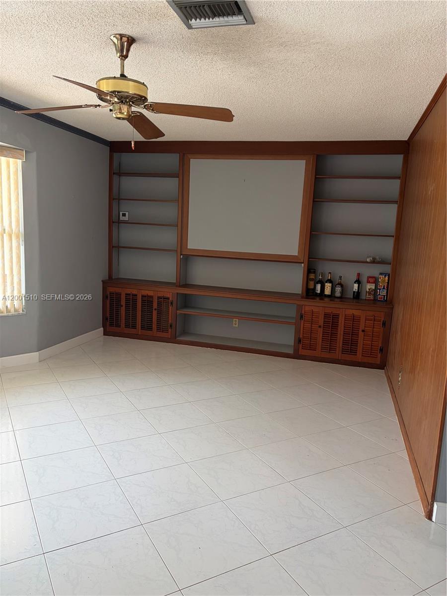 3205 Liberty Street Hollywood, FL 33021 - Photo 9 of 12 a view of room with stairs and a ceiling fan