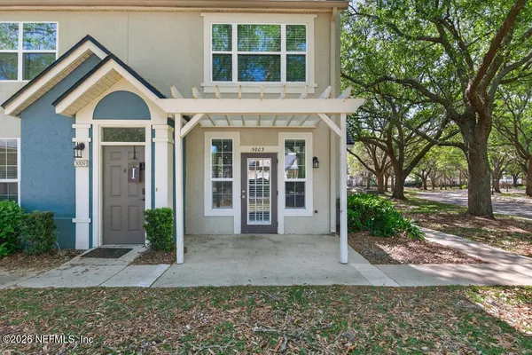 a view of road with house and trees in the background