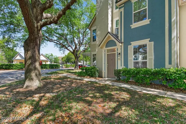 a view of a house with a tree in front of it
