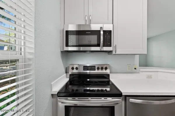 a living room with furniture a flat screen tv and a large window