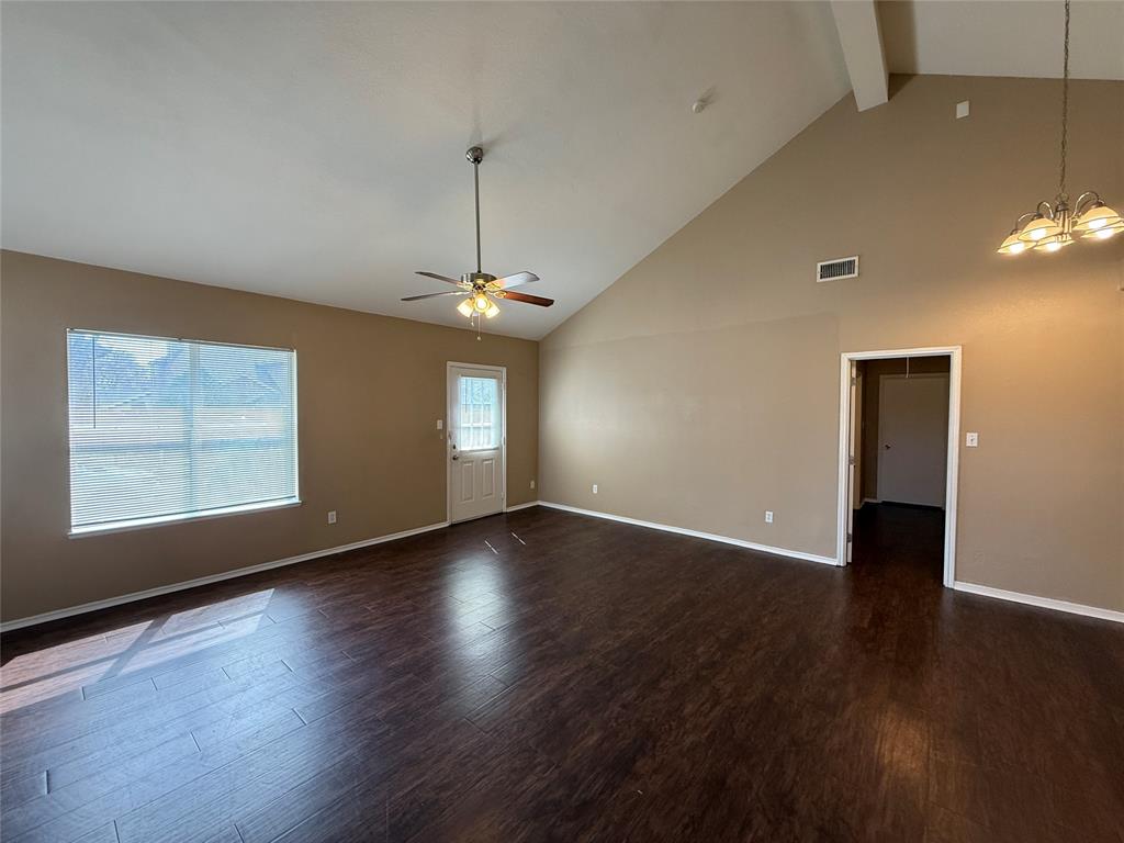 487 Pleasant Meadows Lane Dallas, TX 75217 - Photo 3 of 18 an empty room with wooden floor chandelier and windows