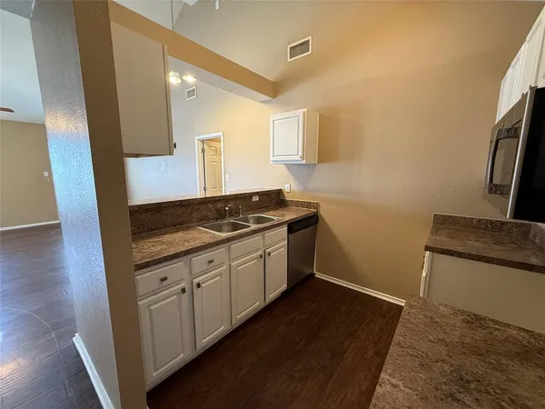 a kitchen with granite countertop a sink and a stove top oven