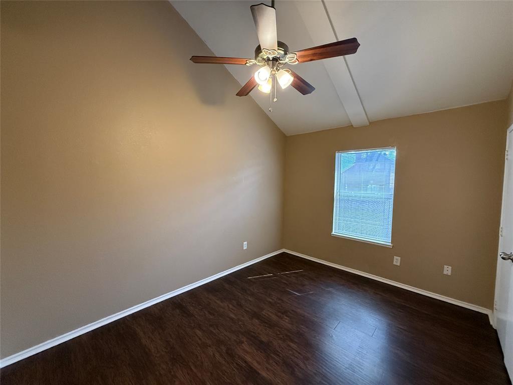 487 Pleasant Meadows Lane Dallas, TX 75217 - Photo 9 of 18 an empty room with wooden floor fan and windows