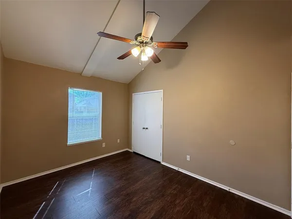 an empty room with a window and a ceiling fan