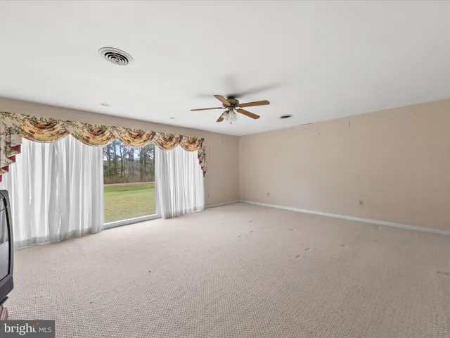 a view of a room with a ceiling fan and a window