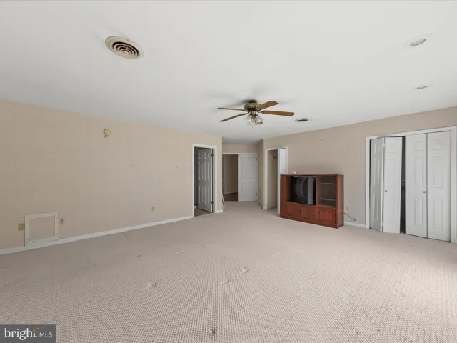 a view of an empty room with a ceiling fan