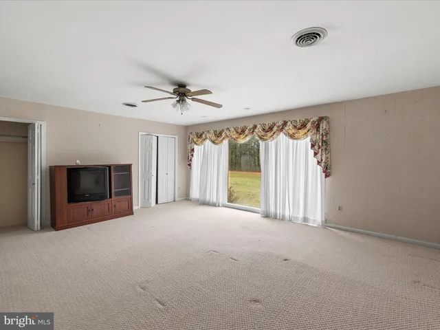 a view of an empty room with a fireplace and a window