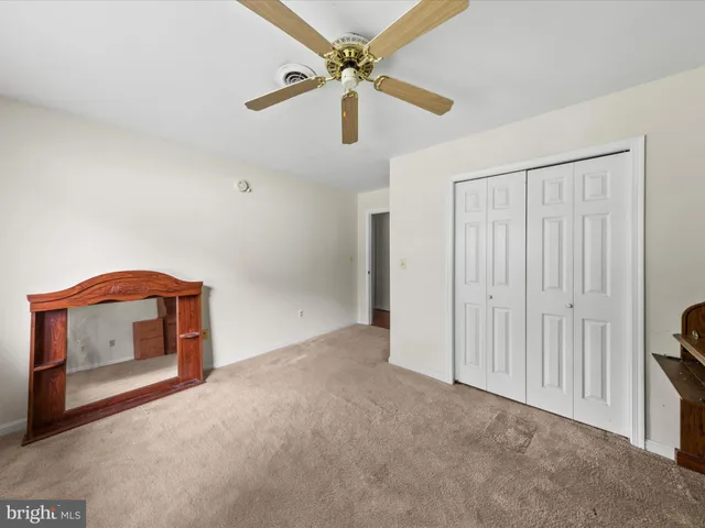 a view of an empty room with a ceiling fan and a window