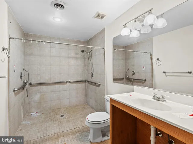 a bathroom with a sink toilet mirror and shower
