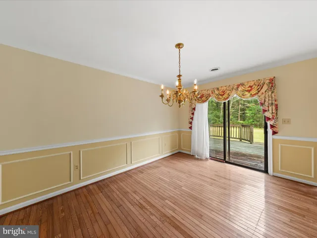 a view of a livingroom with wooden floor and a chandelier