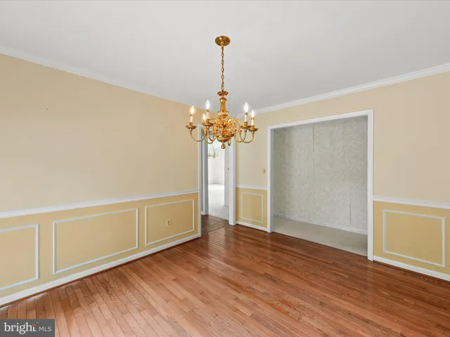 a view of a room with wooden floor and chandelier
