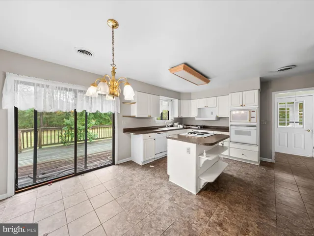 a kitchen with kitchen island granite countertop a stove a sink and a refrigerator