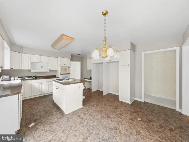 a kitchen with a refrigerator and white cabinets