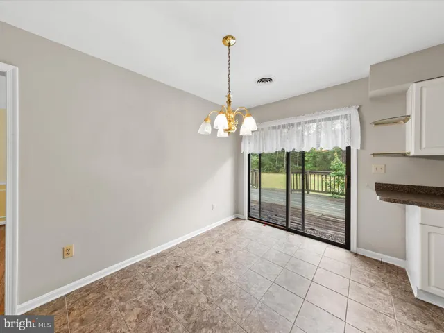 a view of empty room with window and ceiling fan
