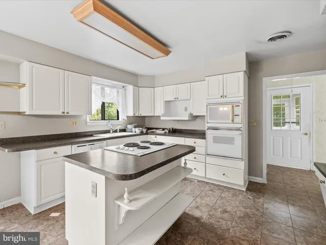 a kitchen with cabinets appliances a sink and a window
