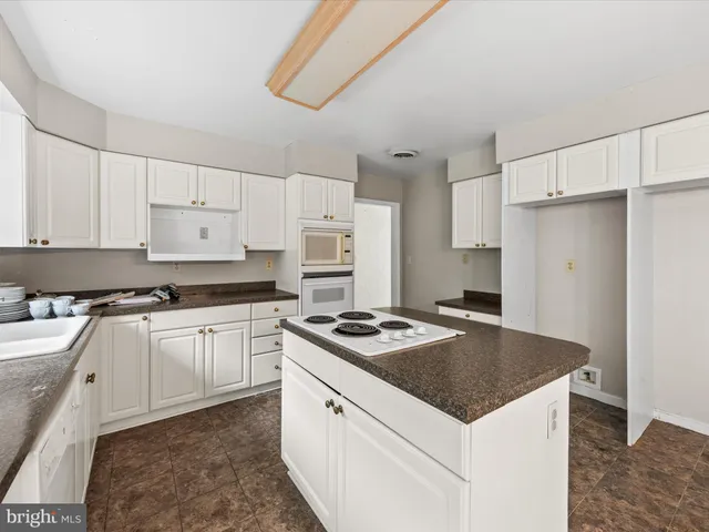 a kitchen with granite countertop a sink stove and refrigerator