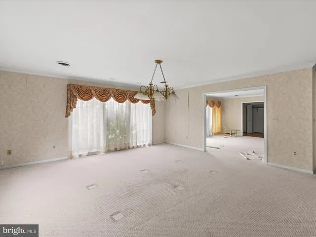 en empty room with windows and a ceiling fan