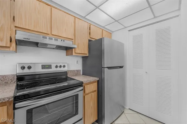 a kitchen with stainless steel appliances a refrigerator stove and cabinets