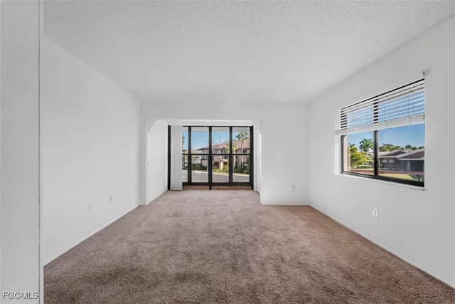an empty room with windows and ceiling fan