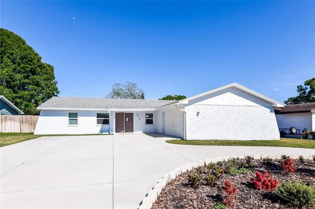 a front view of a house with a garden and yard
