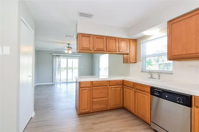a kitchen with stainless steel appliances granite countertop a sink a stove cabinets and wooden floor