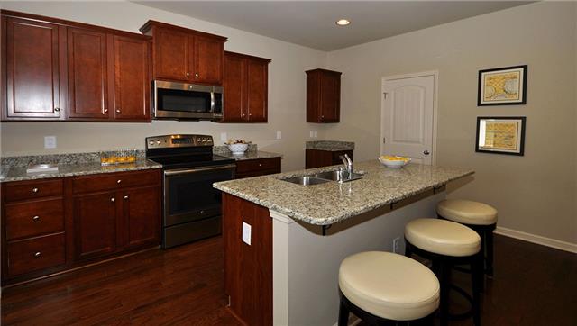 3937 Cannonsgate Lane Murfreesboro, TN 37128 - Photo 3 of 8 a kitchen with a sink a stove a microwave and wooden cabinets
