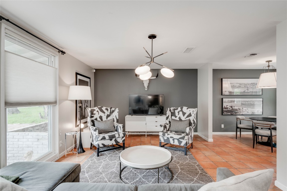 a living room with furniture a chandelier and a large window