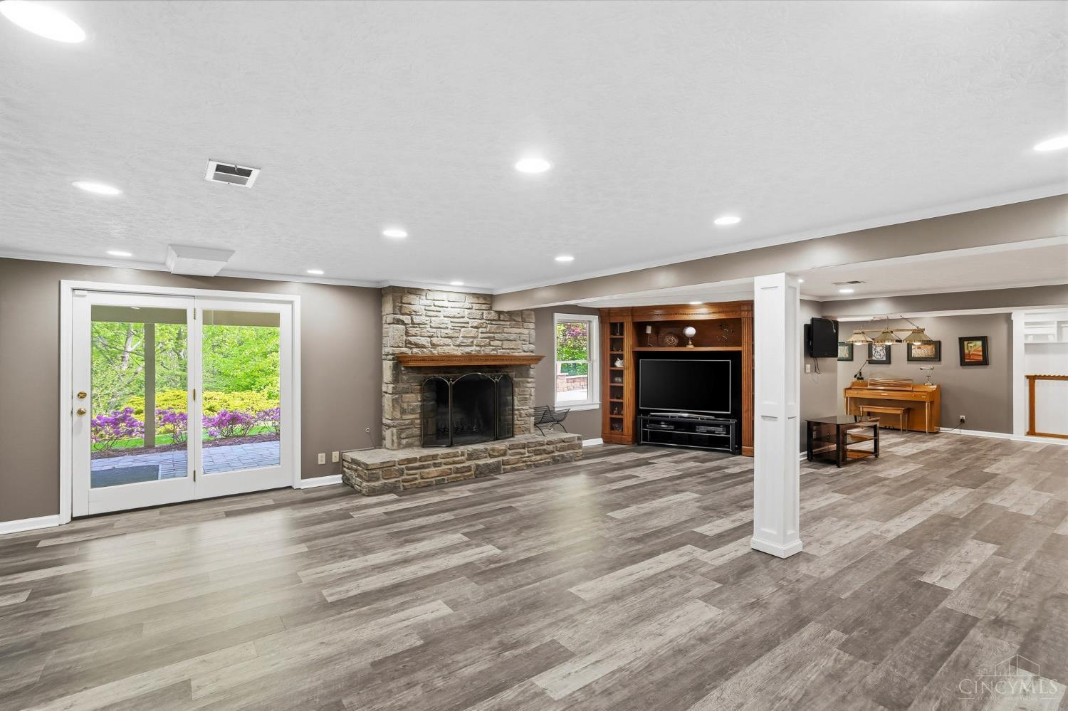 2780 Walsh Road Cincinnati, OH 45208 - Photo 40 of 68 The finished lower level offers exceptional versatility and scale, anchored by a spacious second family room with a striking stone fireplace, built-in media cabinetry, and walkout access to the outdoors—creating an ideal setting for both everyday living and entertaining. This expansive level continues with a full kitchen, dedicated game room, hobby room, exercise space, abundant storage and a convenient half bath. Thoughtfully designed to accommodate a variety of lifestyles, it functions effortlessly as an extension of the home’s living space with room to gather, relax, and play.