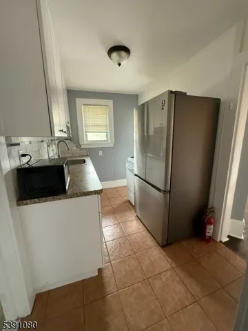 a kitchen with metallic refrigerator and sink